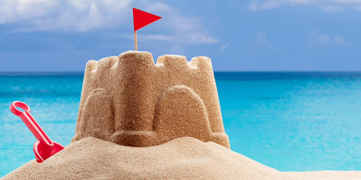 small sand castle and shovel on a beach